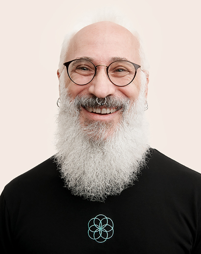 Persona del equipo de Apple Retail con barba blanca sonriendo a la cámara.