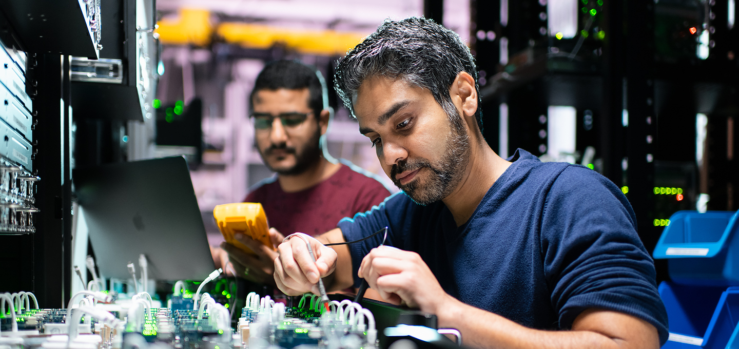 Dois engenheiros da Apple trabalham em componentes do iPhone em um laboratório