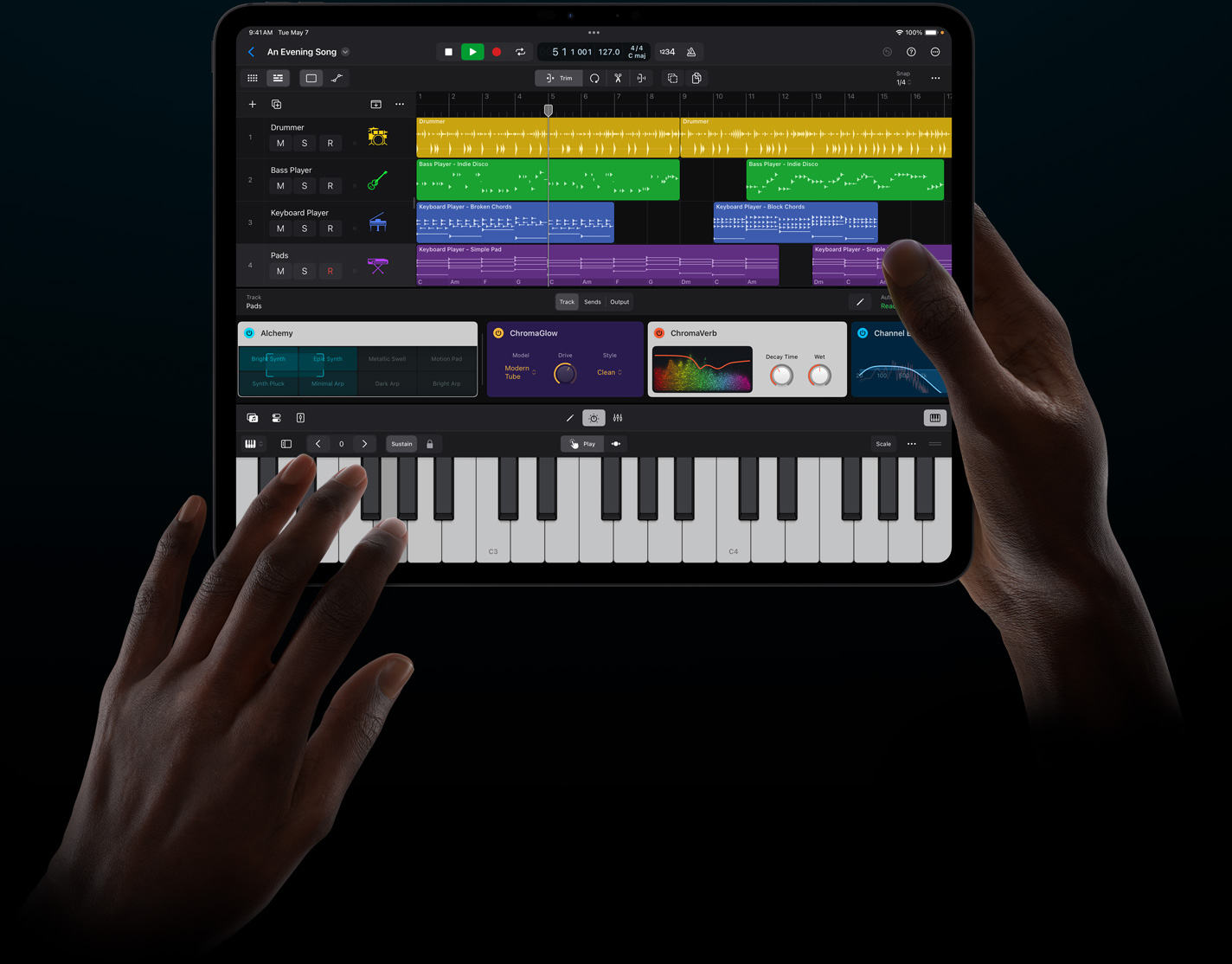 iPad Proを持った手が、iPadのためのLogic Proのバーチャル音源をタッチ操作で演奏している。