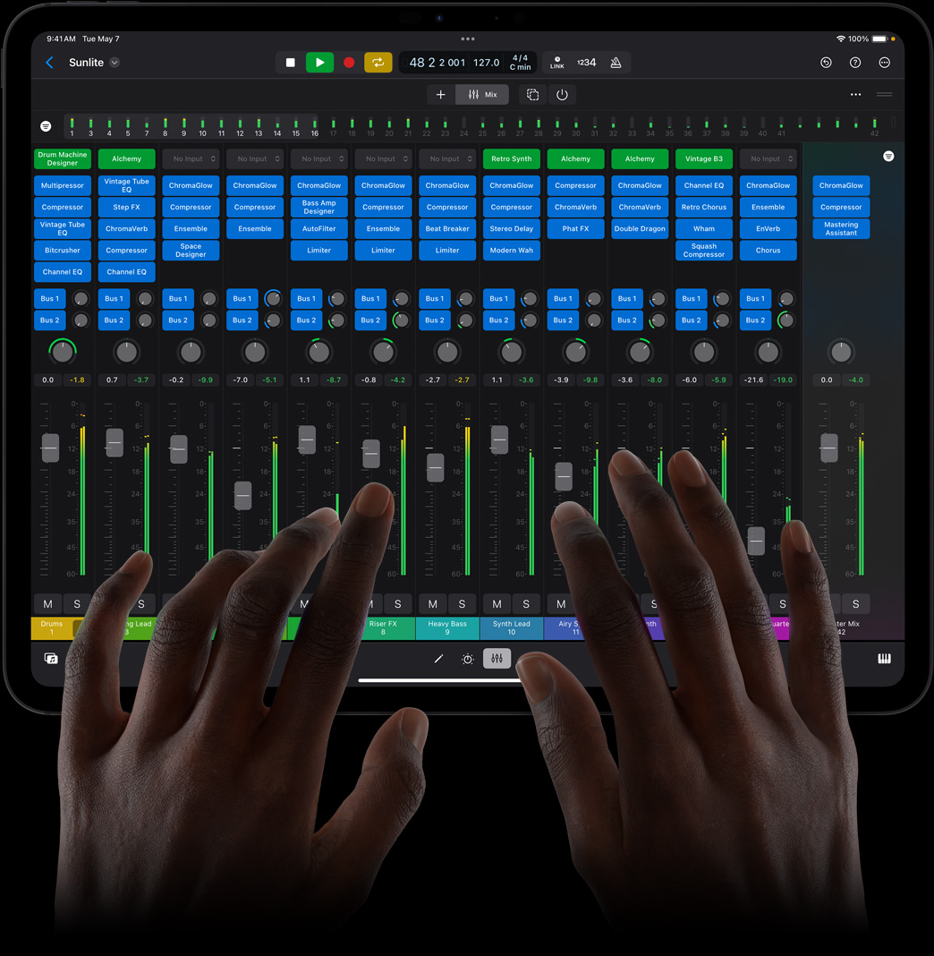 Unas manos controlan una mesa de mezclas en Logic Pro para el iPad usando un iPad Pro.